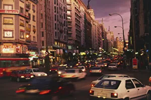 Rear, blurred view of the tail-lights of cars in a congested Spanish city at nightfall