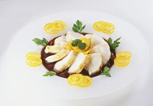 Roasted monkfish, sliced on a bed of garlic sauce, with a garnish of yellow tomatoes Roasted monkfish, sliced on a bed of garlic sauce, with a garnish of yellow tomatoes