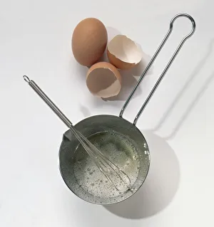 Saucepan, wire whisk, egg and egg shells Saucepan, wire whisk, egg and egg shells