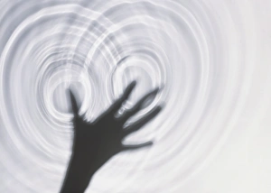 Sillhouettes of a hand two sets of water ripple-rings formed around it illustrating Sillhouettes of a hand two sets of water ripple-rings formed around it illustrating