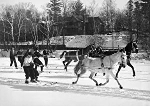 <b class=qtipBold><figcaption>Skijoring At Lake Placid</figcaption></b><br>Lake Placid, New York: December 26, 1936 Skijoring in the Adirondacks. On frozen Mirror Lake, a group of skiers holds tight as horses pull them along.<br><em>© Underwood Archives/UIG</em> Skijoring At Lake Placid