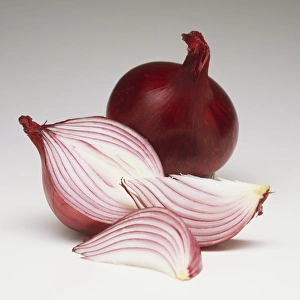 Whole and sliced red onion, half a red onion, red onion wedges, close up
