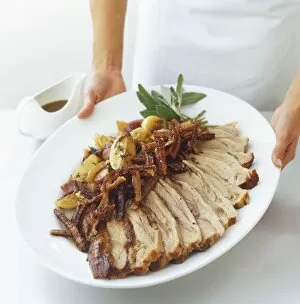 Gravy Collection: Sliced roast pork served with crackling, onions, lemons and fresh sage, view from above
