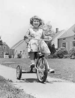 <b class=qtipBold><figcaption>Smiling girl on tricycle</figcaption></b> Smiling girl on tricycle