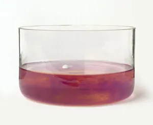Sodium metal in glass bowl of red Litmus water producing sodium hydroxide and hydrogen Sodium metal in glass bowl of red Litmus water producing sodium hydroxide and hydrogen