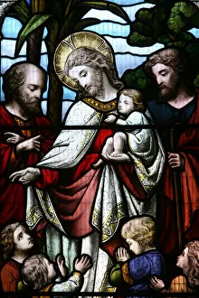 Stained glass window depicting Jesus welcoming children