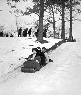 <b class=qtipBold><figcaption>Tobogganing in 1900</figcaption></b><br>United States: c. 1900 A woman in Victorian style dress with two male friends heading down a hill on a toboggan.<br><em>© Underwood Archives/UIG</em> Tobogganing in 1900