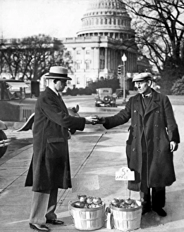 <b class=qtipBold><figcaption>Unemployed Man Sells Apples</figcaption></b><br>Washington, D.C.: 1930. Congressman Fred Hartley Jr. of New Jersey buys an apple from one of the unemployed apple vendors in Washington.<br><em>© Underwood Archives/UIG</em> Unemployed Man Sells Apples