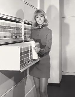 <b class=qtipBold><figcaption>Woman at file cabinet in office</figcaption></b> Woman at file cabinet in office