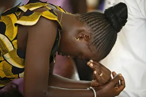 Woman praying at mass in Popenguine Woman praying at mass in Popenguine