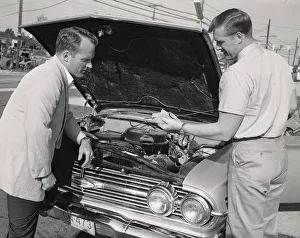Worker checking the oil of a car Worker checking the oil of a car