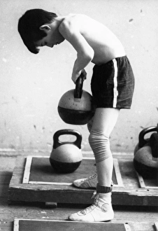 A young boy at the sambo-70 sports school lifting weights as he trains to be a sambo A young boy at the sambo-70 sports school lifting weights as he trains to be a sambo