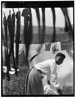 Young smiling Black woman surrounded by laundry Young smiling Black woman surrounded by laundry