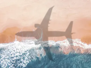 Aerial view of an airplane shadow over a sandy beach Aerial view of an airplane shadow over a sandy beach