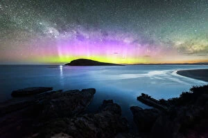 Display Gallery: Colourful display of the Aurora Australis over an island in the ocean at Blue Hour