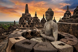 Borobudur Temple Compounds Gallery: Sunrise with a Buddha Statue with the Hand Position of Dharmachakra Mudra in Borobudur, Magelang