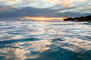 Sunrise in the water seeing the first light hit the ripples on the ocean surface Sunrise in the water seeing the first light hit the ripples on the ocean surface