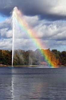 Alster Fountain, water fountain creating a rainbow on the Inner Alster Lake in the center Alster Fountain, water fountain creating a rainbow on the Inner Alster Lake in the center
