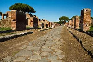 An ancient road in the ruins of the Ancient Roman harbour city of Ostia Antica in Rome An ancient road in the ruins of the Ancient Roman harbour city of Ostia Antica in Rome