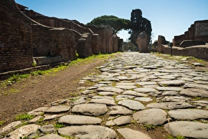 An ancient Roman road in the ruins of the Ancient Roman harbour city of Ostia Antica in An ancient Roman road in the ruins of the Ancient Roman harbour city of Ostia Antica in