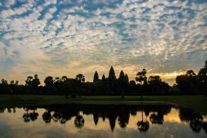 Temple Building Collection: Angkor Wat temple at sunrise reflecting in water