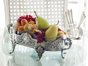 Antique silver fruit bowl with fruit in a sophisticated atmosphere on a breakfast table