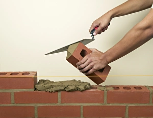 Applying mortar to a new brick with a trowel Applying mortar to a new brick with a trowel