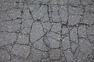 Asphalt cracked by frost and cold, potholes in Berlin, Germany, Europe Asphalt cracked by frost and cold, potholes in Berlin, Germany, Europe