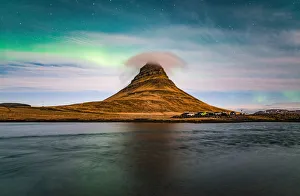 Aurora borealis and cloud cap over the Kirkjufell mountain the iconic landmark of west Aurora borealis and cloud cap over the Kirkjufell mountain the iconic landmark of west