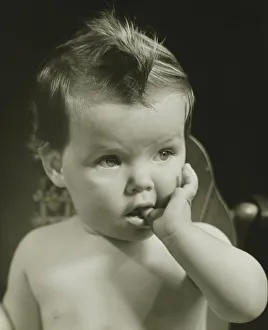 Baby boy (6-9 months) with thumb on mouth, (B&W), portrait Baby boy (6-9 months) with thumb on mouth, (B&W), portrait