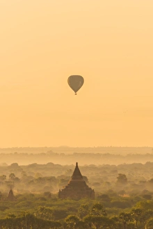 <b class=qtipBold><figcaption>A balloon flying over Bagan, Myanmar</figcaption></b><br>The misty landscape of The Bagan Archaeological zone (Unesco Heritage Site) with silhouttes of hot air balloons and ancient pagoda at sunrise.<br><em>© Theerayoot Tapina</em> A balloon flying over Bagan, Myanmar