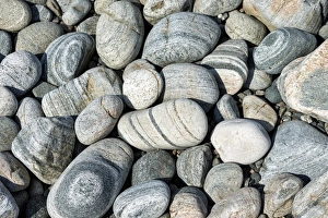 Banded and round gneiss, on the gravel beach, Geopark Scourie Bay, Sutherland, Scotland Banded and round gneiss, on the gravel beach, Geopark Scourie Bay, Sutherland, Scotland