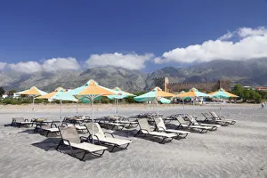 Beach with sun beds, the Venetian castle at the back, Frangokastello, Crete, Greece Beach with sun beds, the Venetian castle at the back, Frangokastello, Crete, Greece