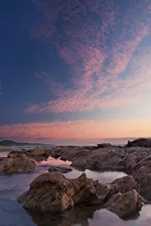Images Dated 7th April 2012: Beautiful soft colour sunrise over the sea with rocks in the foreground - Cape Vidal South Africa