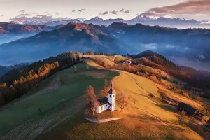 Beautiful Sunrise Landscape Of Saint Thomas Church and Julian Alps In Slovenia Beautiful Sunrise Landscape Of Saint Thomas Church and Julian Alps In Slovenia