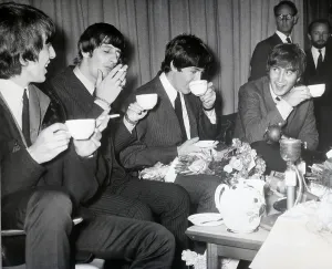 Prints of (Original Caption) 7/2/1964-London, England- Enjoying a cup of coffee on their return to a London airport after their Australian and New Zealand tour are the Beatles Sight Prints: The Beatles Seated Drinking Coffee Print, London 1964