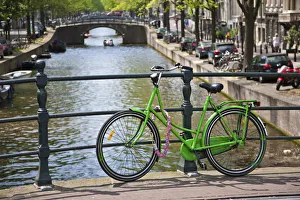 Bicycle on a bridge crossing a canal in the historic city centre of Amsterdam, Holland Bicycle on a bridge crossing a canal in the historic city centre of Amsterdam, Holland
