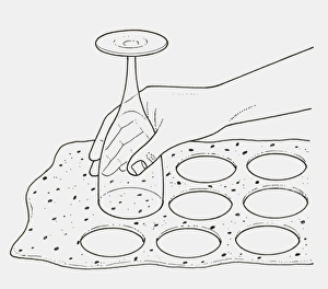 Black and white illustration of using upturned wine glass to cut pastry Black and white illustration of using upturned wine glass to cut pastry