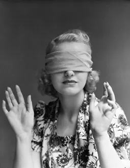 Blindfolded woman holding hands out in front of herself. (Photo by H Blindfolded woman holding hands out in front of herself. (Photo by H