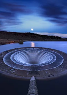 Blue supermoon at dawn over Ladybower Reservoir. English Peak District. UK Blue supermoon at dawn over Ladybower Reservoir. English Peak District. UK