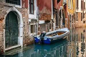 Boat moored by the townhouse door facing canal in Venice, Italy Boat moored by the townhouse door facing canal in Venice, Italy