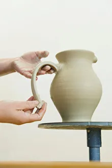 Ceramic artist working in her workshop, pulling a handle for a pitcher, Geisenhausen Ceramic artist working in her workshop, pulling a handle for a pitcher, Geisenhausen