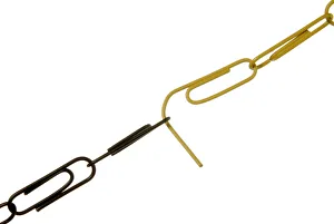 Chain of black and yellow paper clips dissolving where they are joined, symbolic image for problems of the black yellow Chain of black and yellow paper clips dissolving where they are joined, symbolic image for problems of the black yellow
