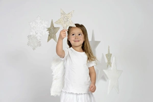 Child, girl wearing an angel costume with stars, Christmas, festive season Child, girl wearing an angel costume with stars, Christmas, festive season