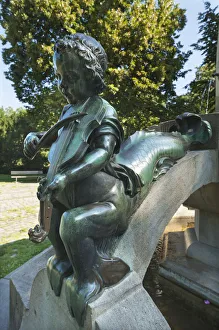 Childs sculpture with musical instrument and fish fin on Minnesangerbrunnen fountain Childs sculpture with musical instrument and fish fin on Minnesangerbrunnen fountain