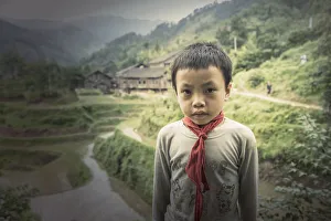 Chinese boy standing in rice paddy fields Chinese boy standing in rice paddy fields