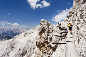 Climber climbing along the Via Ferrata Ivano Dibona climbing route on Monte Cristallo to Climber climbing along the Via Ferrata Ivano Dibona climbing route on Monte Cristallo to