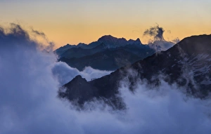 Four climbers on the mountain edge heading to Quintino Sella Hut, with Mont Blanc at the back, Monte Rosa, Alps Four climbers on the mountain edge heading to Quintino Sella Hut, with Mont Blanc at the back, Monte Rosa, Alps