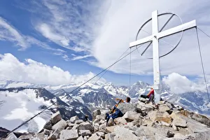Climbers by the summit cross, Mt Vertainspitze, Ortler range Climbers by the summit cross, Mt Vertainspitze, Ortler range