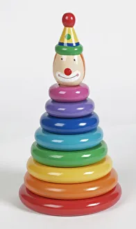 Colourful plastic rings stacked on pole with smiling clown head at the top, close up Colourful plastic rings stacked on pole with smiling clown head at the top, close up